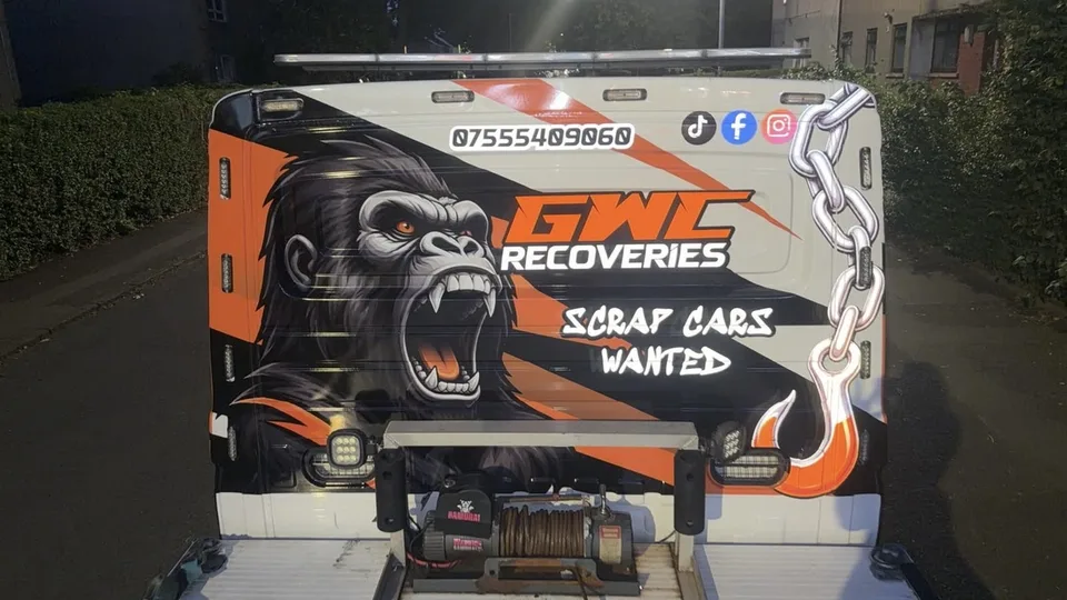 Rear of the recovery truck with a gorilla illustration, chain and hook artwork, and black and orange graphics.