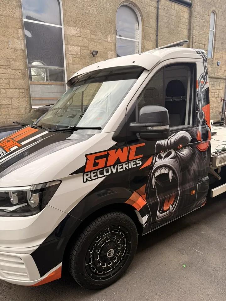 Close side view of the recovery truck cab showing the gorilla artwork and orange branding.
