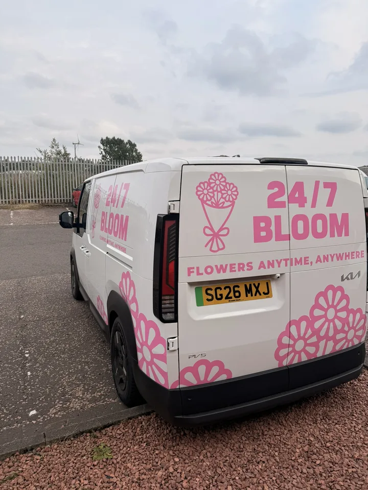 Rear view of the white delivery van showing pink bouquet icons, business lettering and flower motifs.