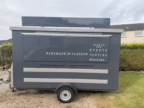 Full serving-side view of the grey catering trailer before the black wrap and Paisley Pie Co branding.