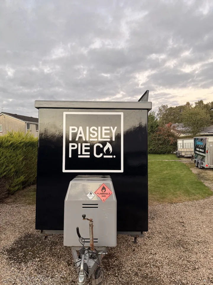 Front of the completed Paisley Pie Co trailer with a large white logo above the gas locker and tow hitch.
